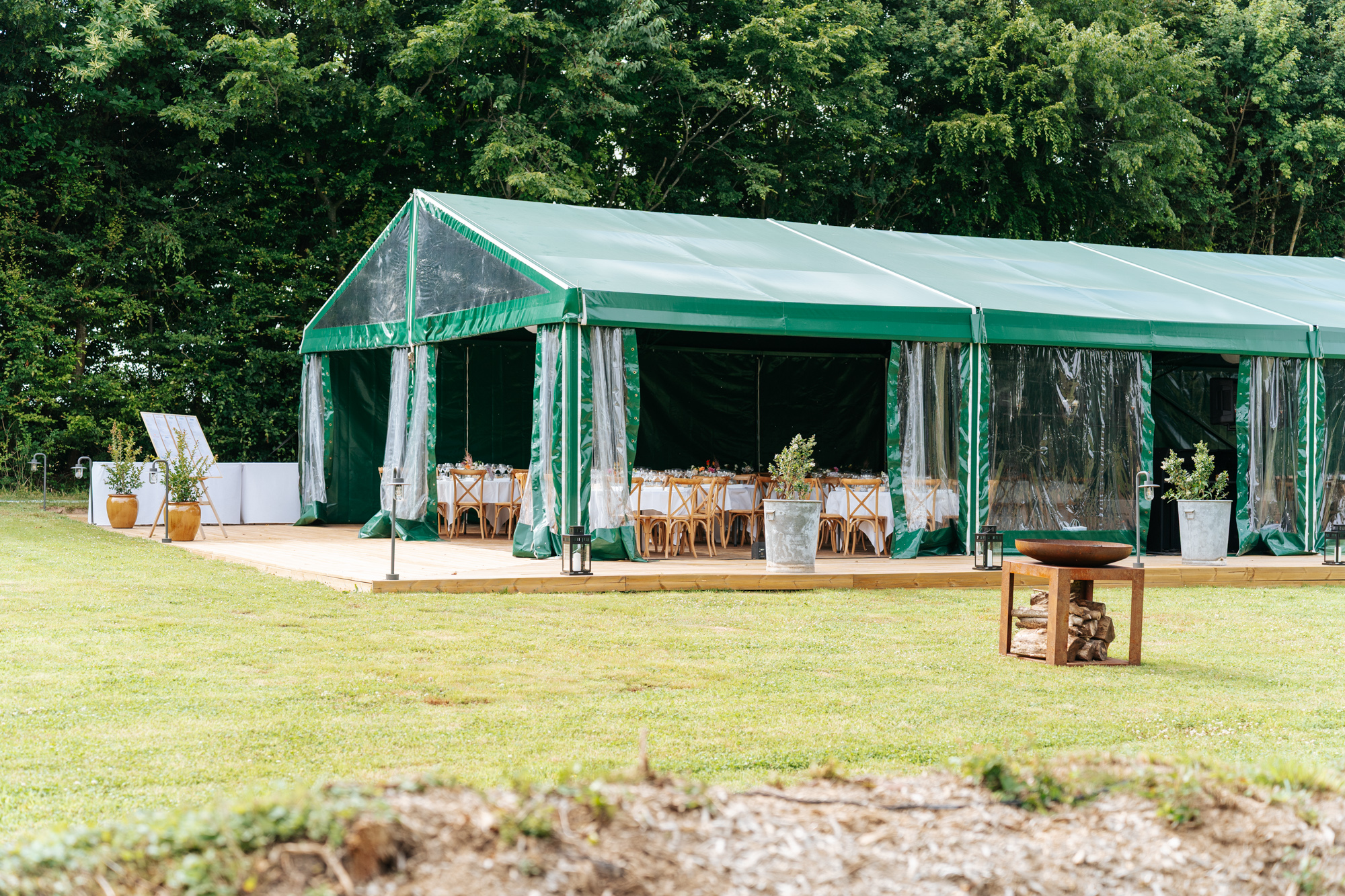 Wedding ceremony setup with floral decorations and the charming manor house in the background at Domaine de Barneville.