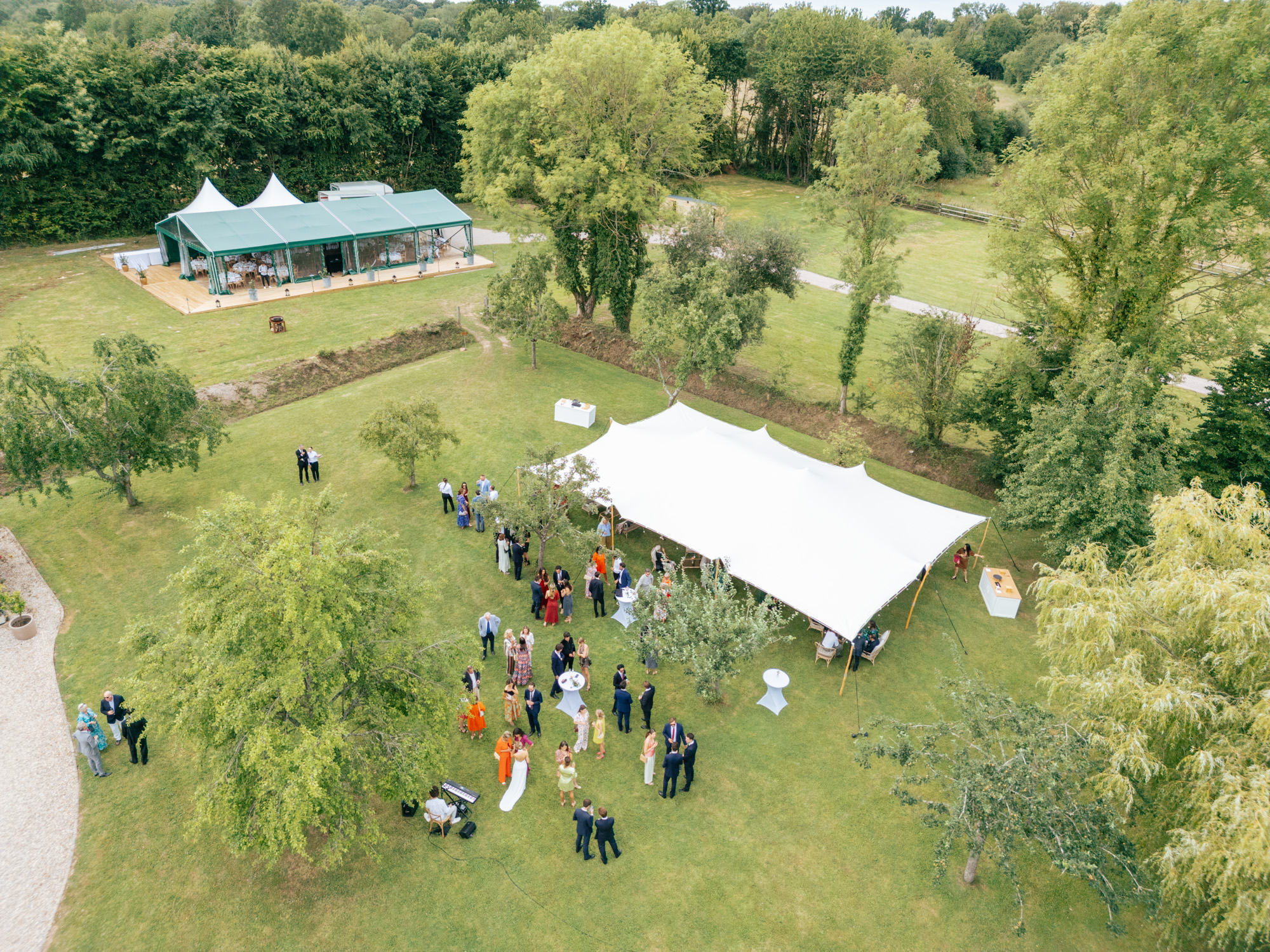 Stretch tent set up for a wedding at Domaine de Barneville with garden seating and floral decorations.