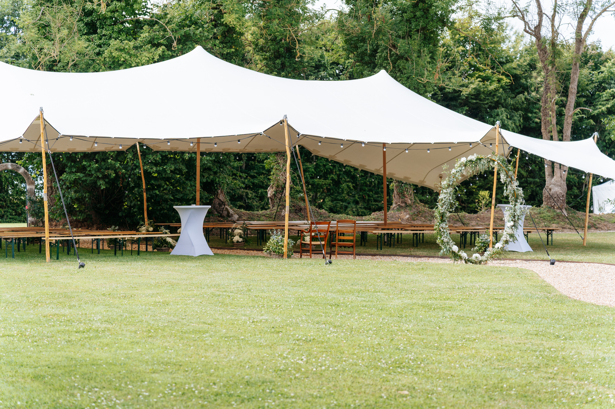 Aerial view of Domaine de Barneville with the ceremony tent, manor house, and surrounding lush green fields.