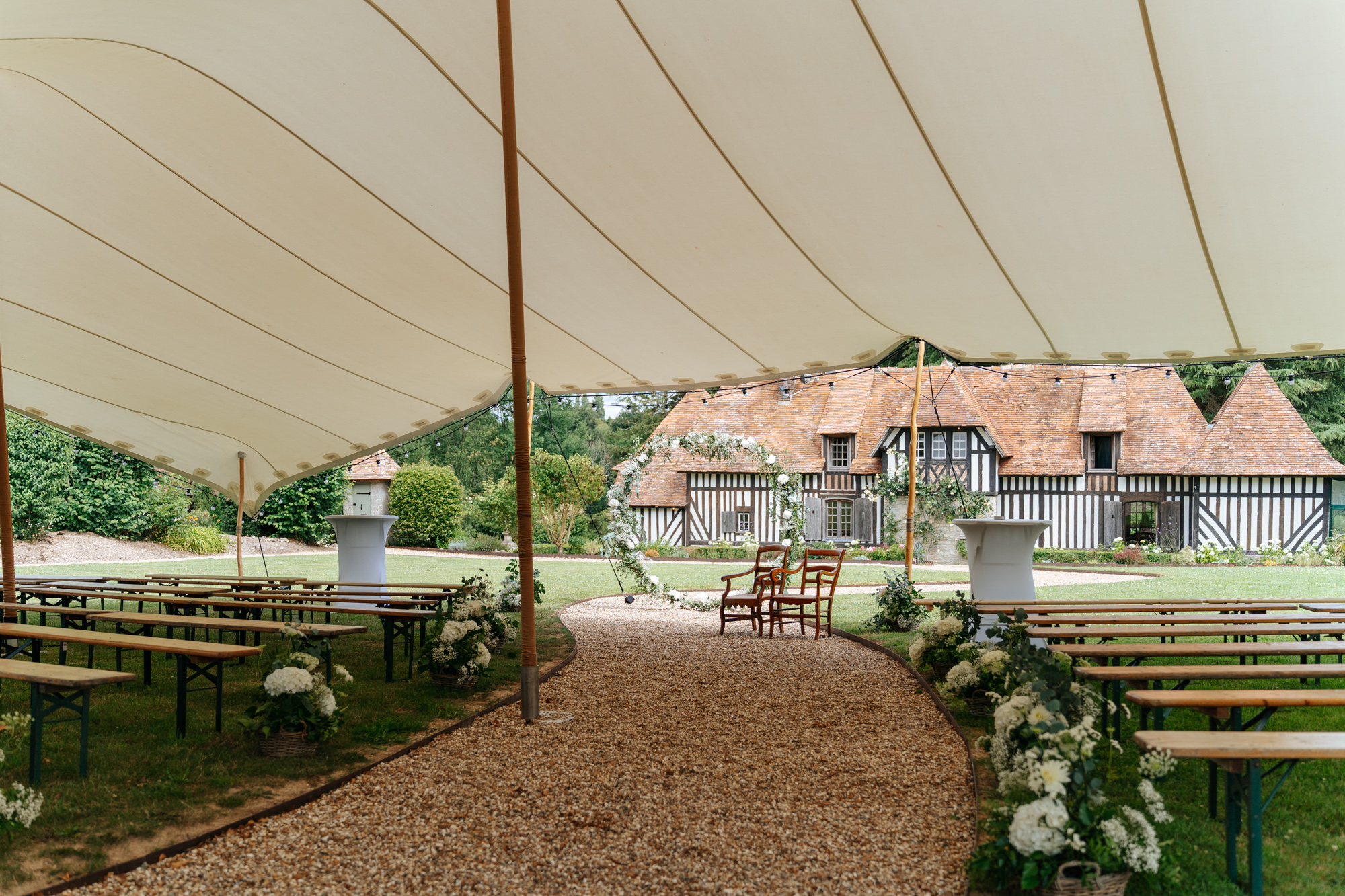 Aerial view of Domaine de Barneville with the reception tents and the manor house, surrounded by lush greenery.